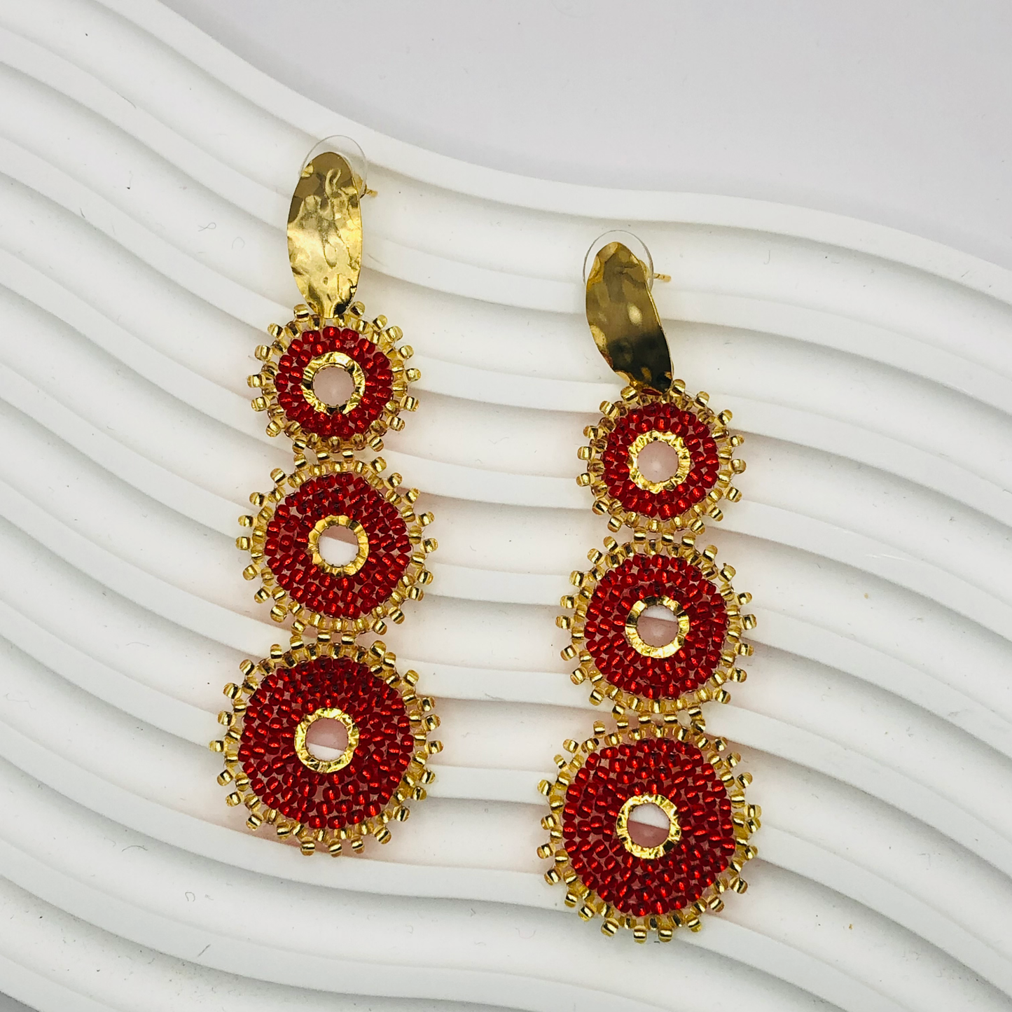 A pair of gold-plated Nala Earrings with intricate detailing, displayed elegantly against a soft velvet background, capturing their luxurious and timeless appeal.