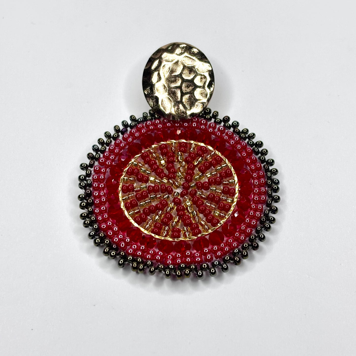 Decorative pendant with red and gold design on a white background