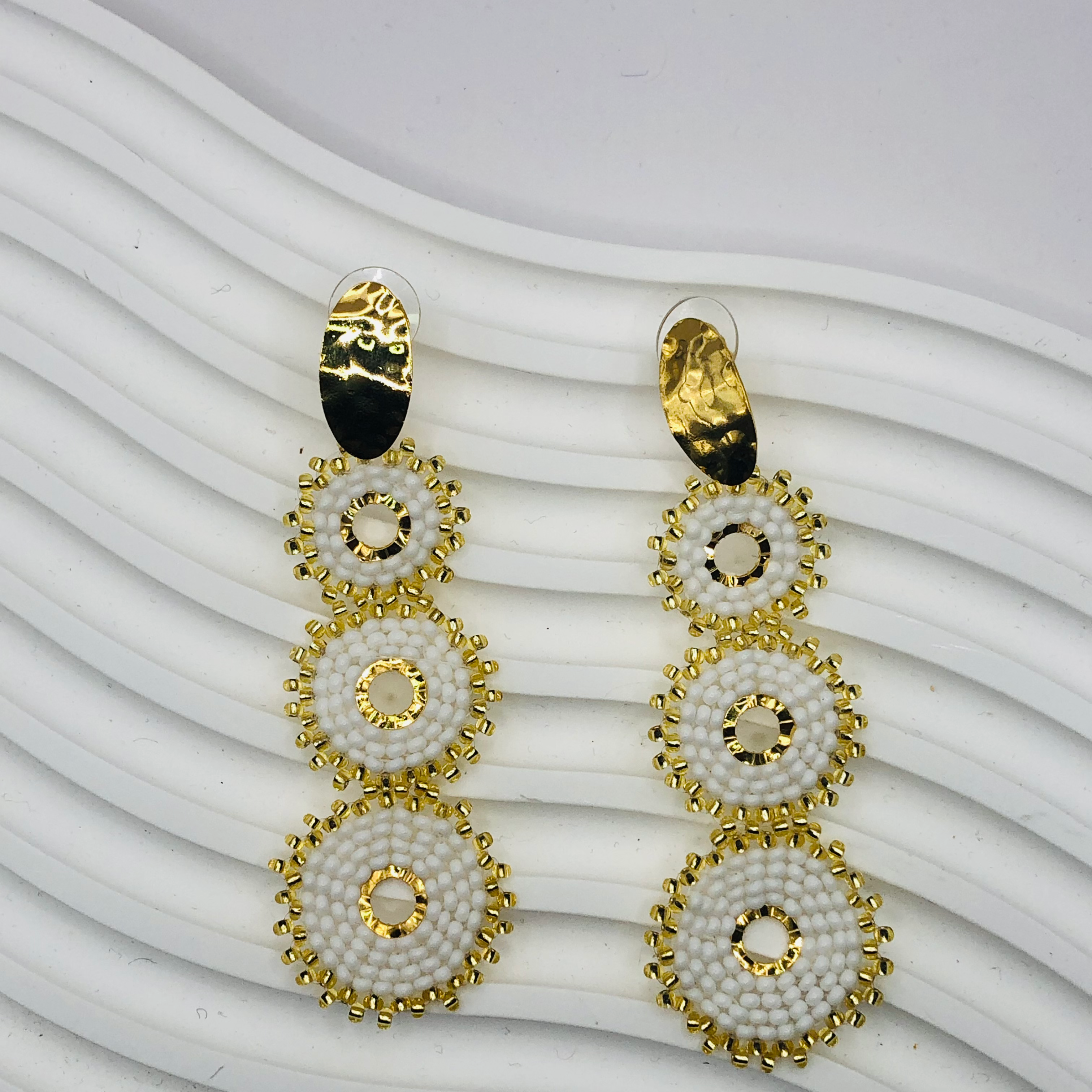 A pair of gold-plated Nala Earrings with intricate detailing, displayed elegantly against a soft velvet background, capturing their luxurious and timeless appeal.