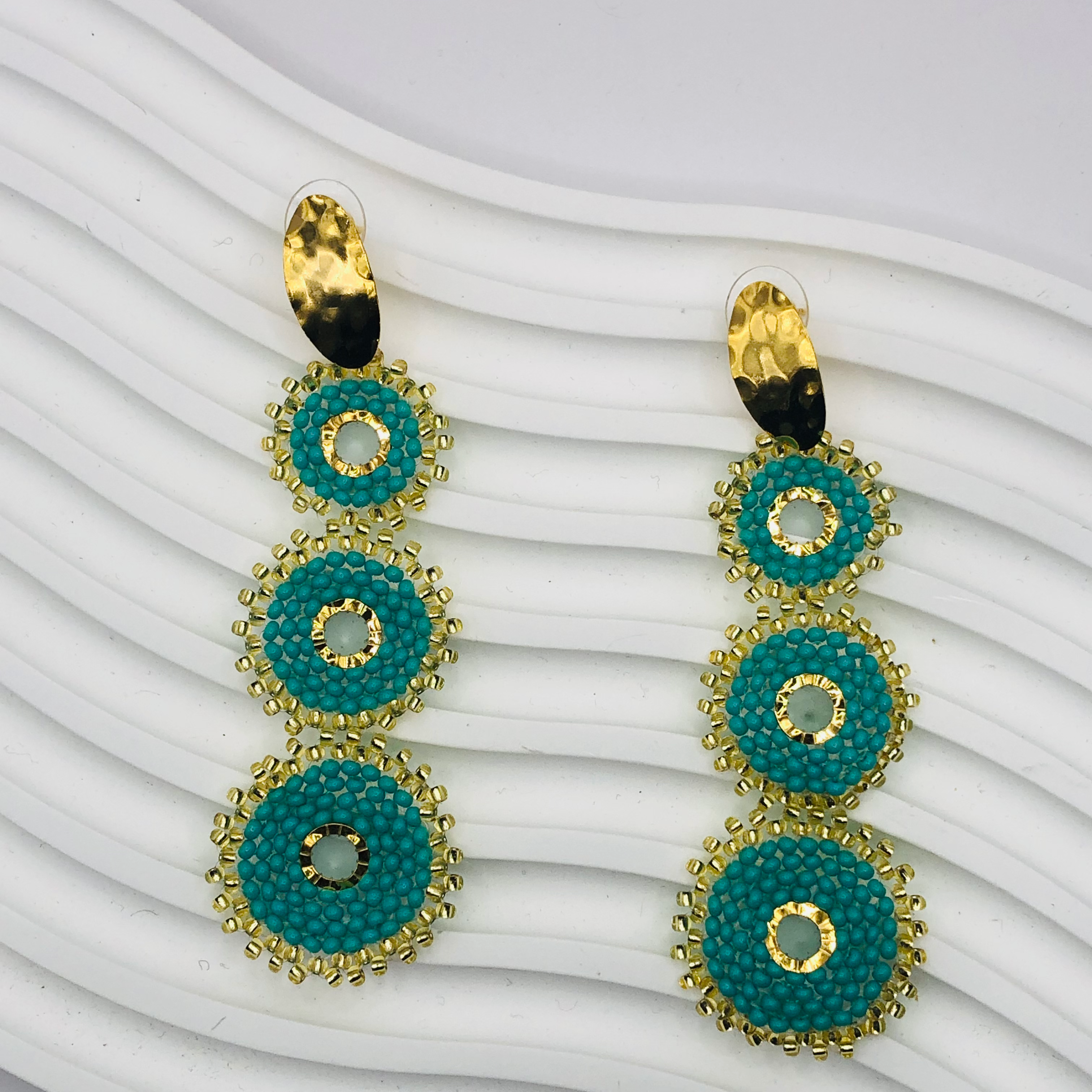 A pair of gold-plated Nala Earrings with intricate detailing, displayed elegantly against a soft velvet background, capturing their luxurious and timeless appeal.