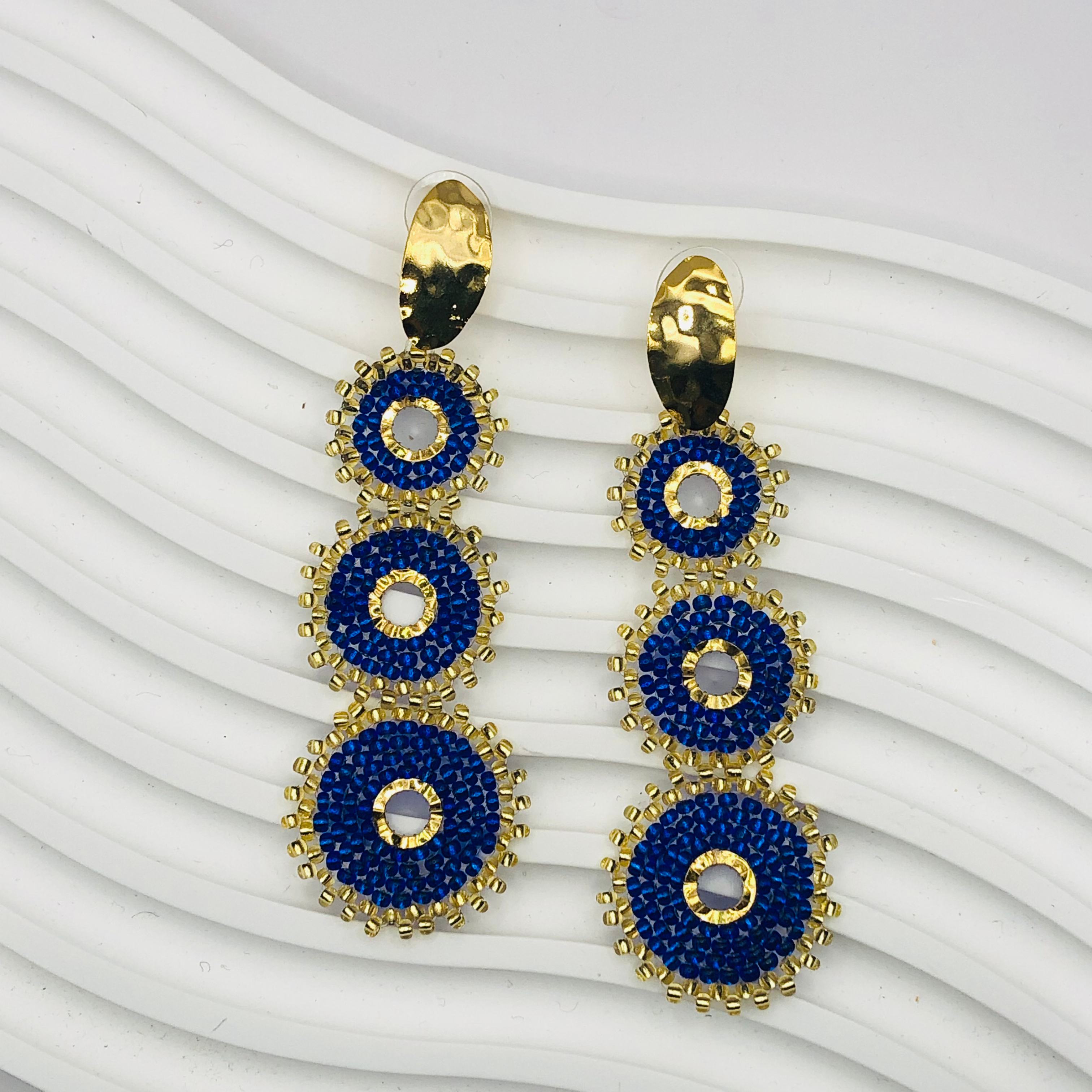 A pair of gold-plated Nala Earrings with intricate detailing, displayed elegantly against a soft velvet background, capturing their luxurious and timeless appeal.