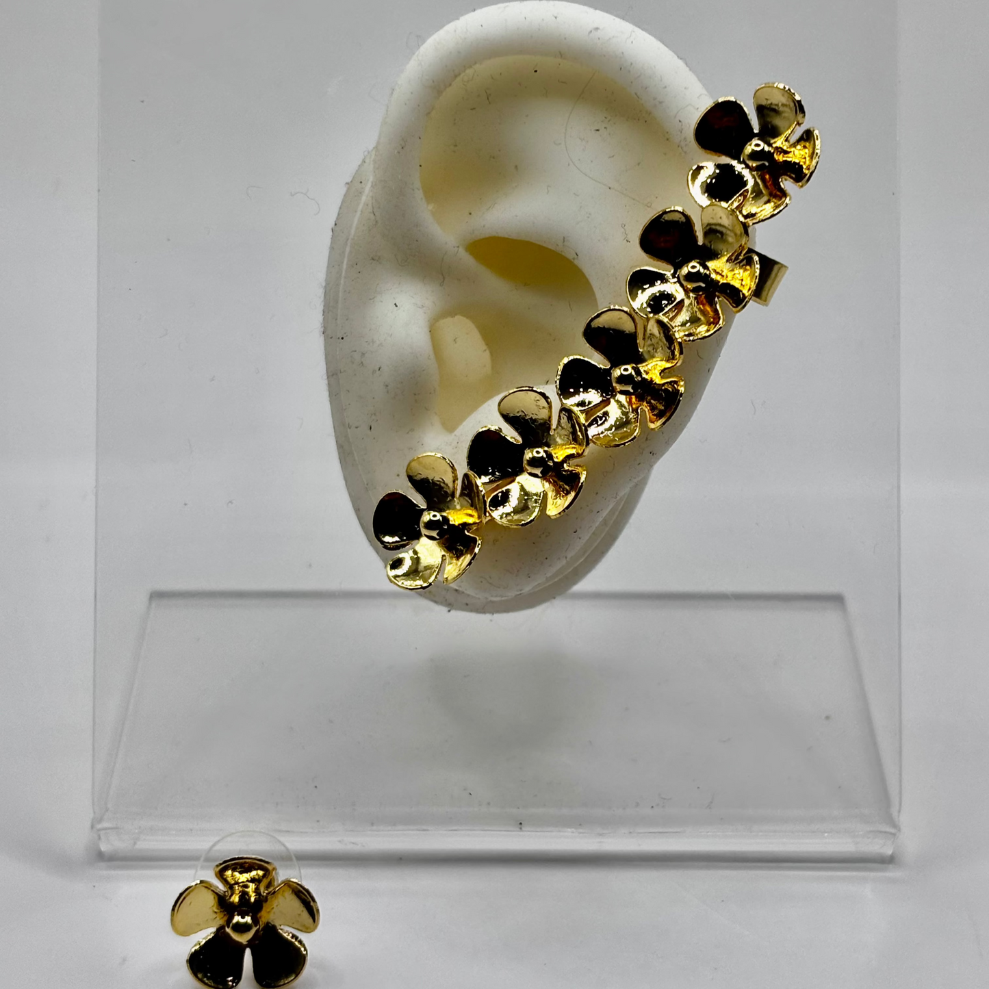 Gold floral ear cuff featuring polished flower designs, displayed with a matching flower stud earring for a chic and elegant look