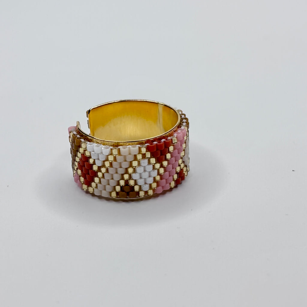 Beaded ring with geometric pattern on a white background