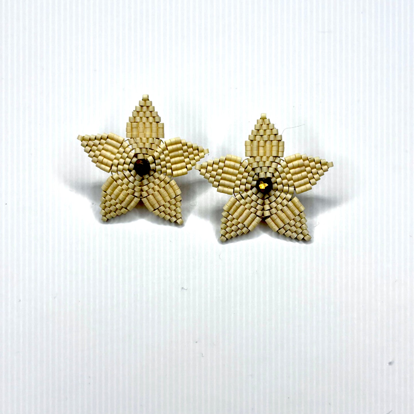 Star-shaped earrings made of beaded material on a white background