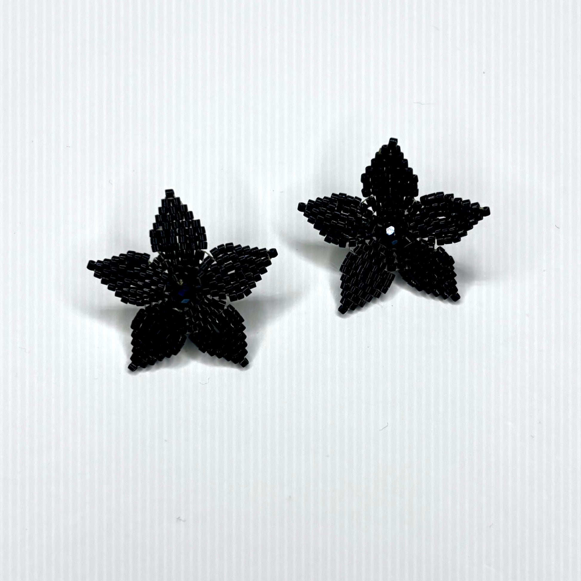 Black beaded flower earrings on a white background