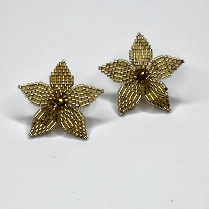 Pair of gold starfish-shaped earrings on a white background