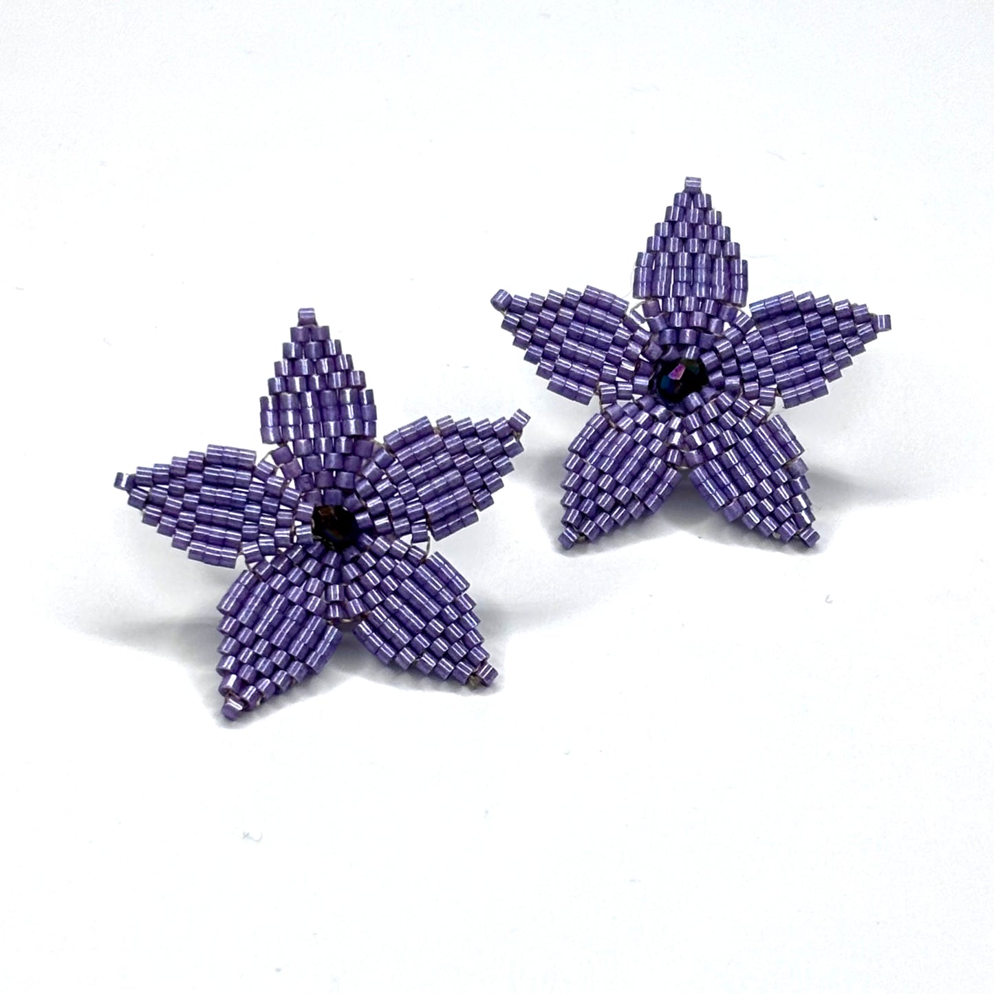 Purple beaded flower earrings on a white background