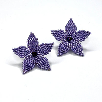 Purple beaded flower earrings on a white background