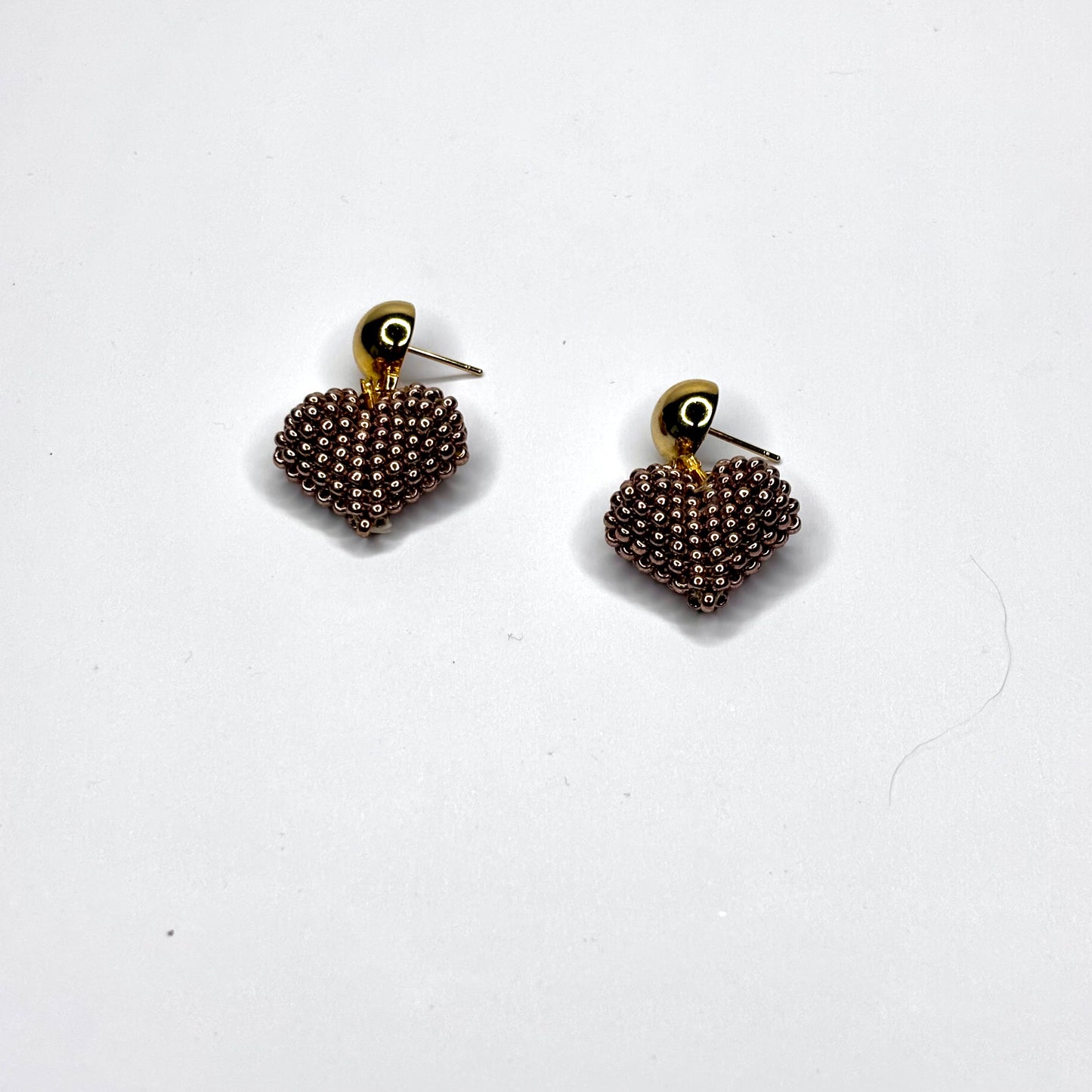 Pair of beaded heart-shaped earrings on a white background