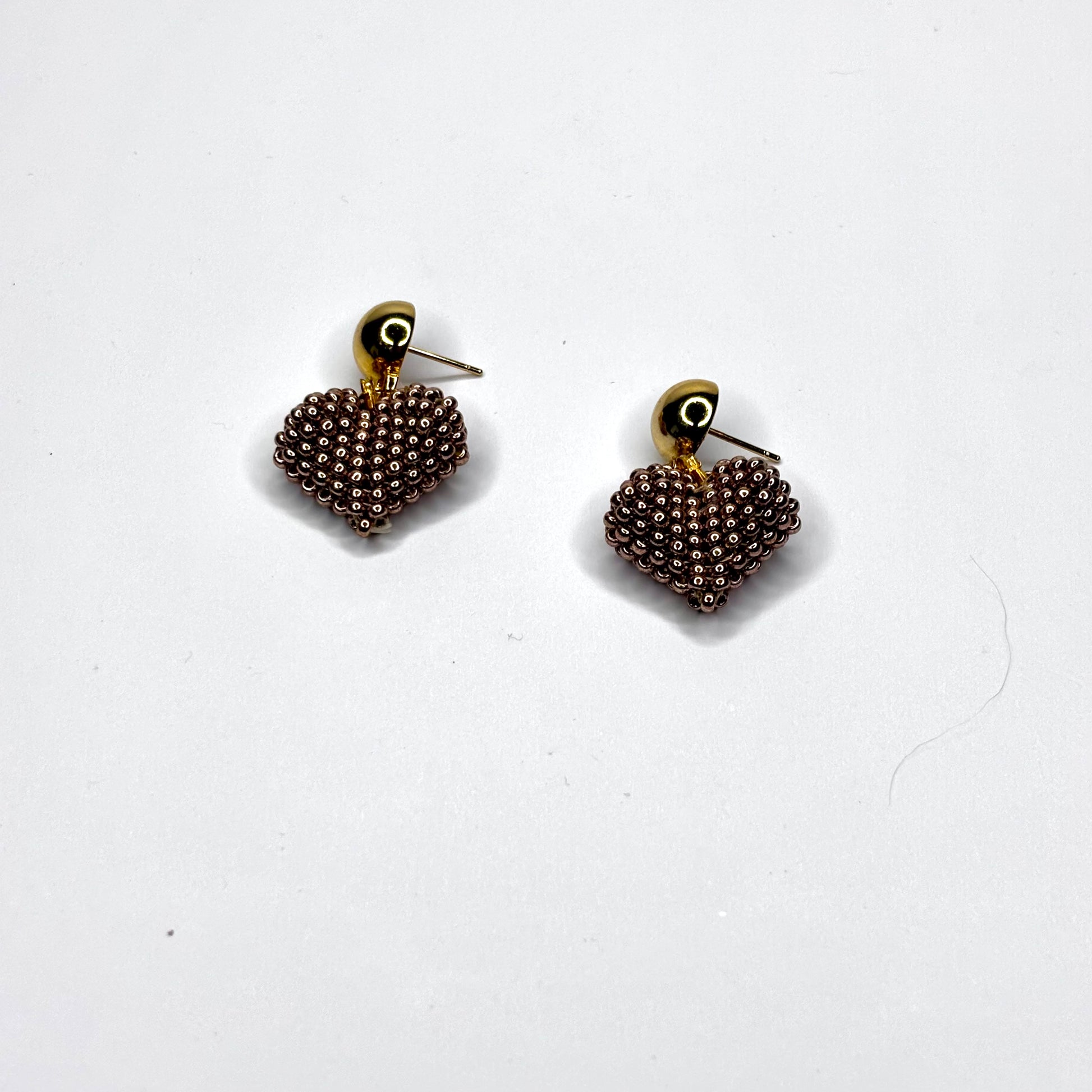 Pair of beaded heart-shaped earrings on a white background