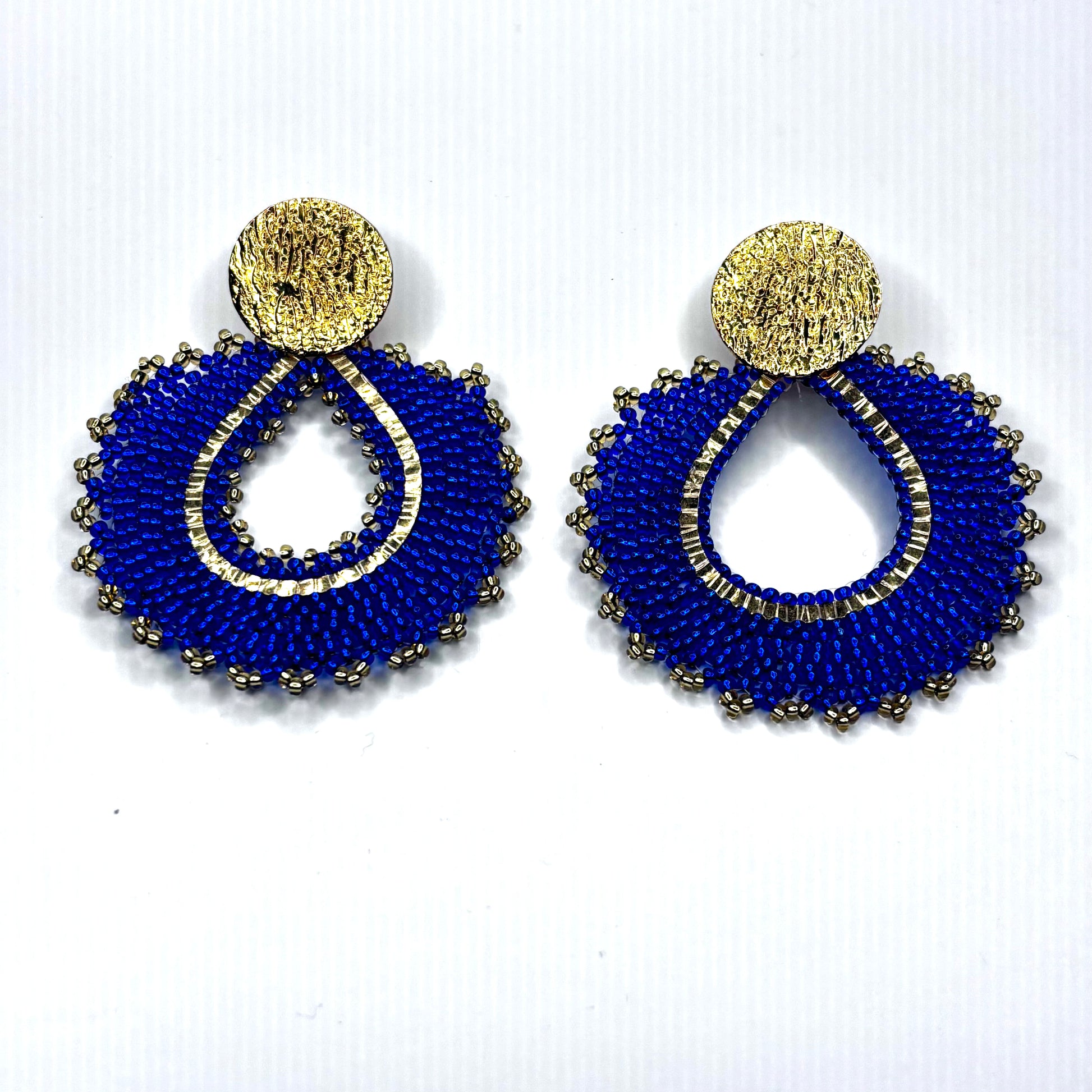 Pair of blue beaded earrings with gold accents on a white background