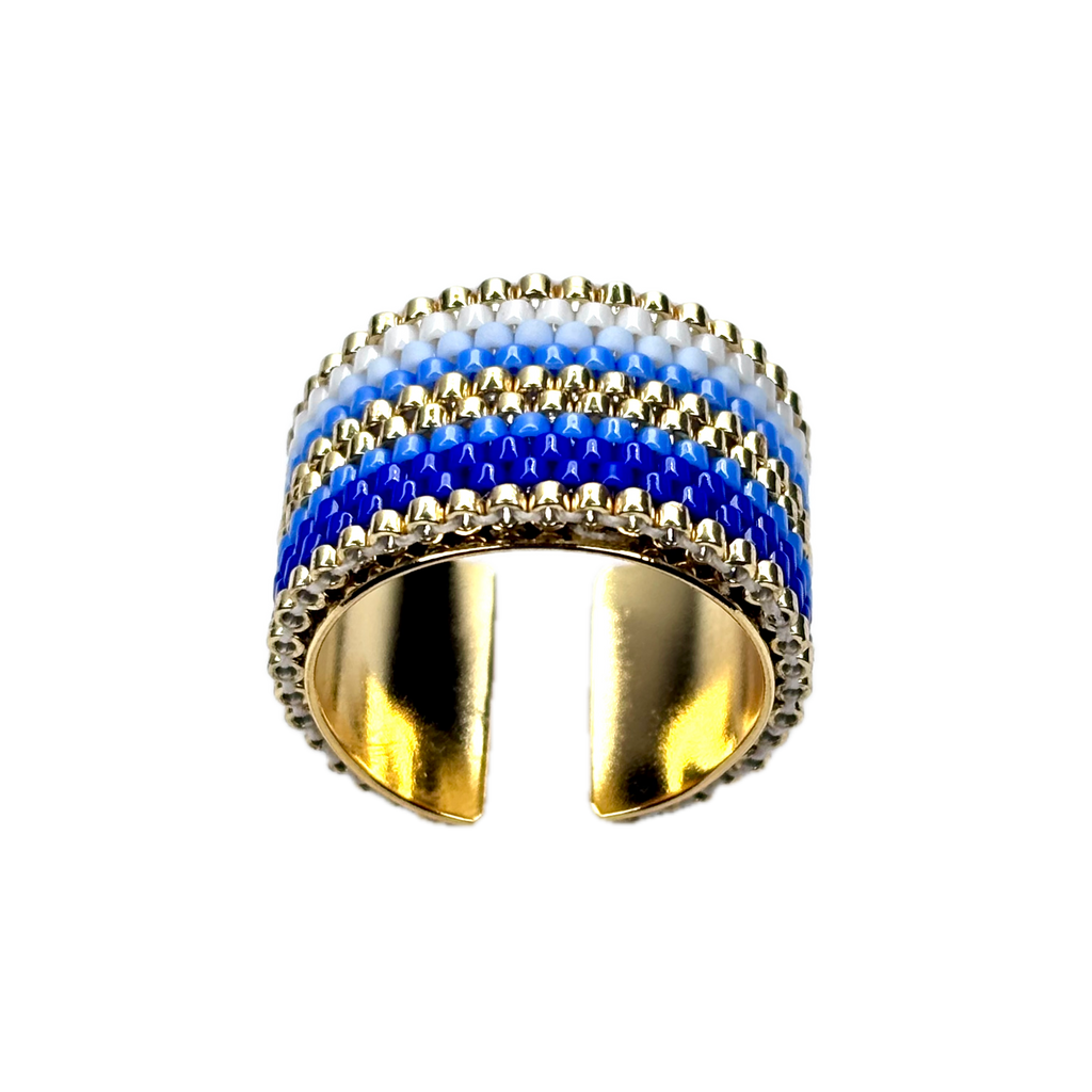 Gold ring with blue and white striped design on a black background