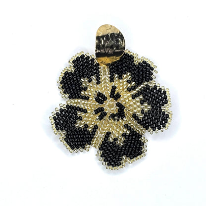 Gold and black beaded flower-shaped earring on a white background
