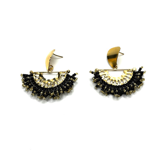 Pair of gold and black earrings on a white background