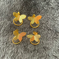 Gold butterfly-shaped door handles on a gray textured surface