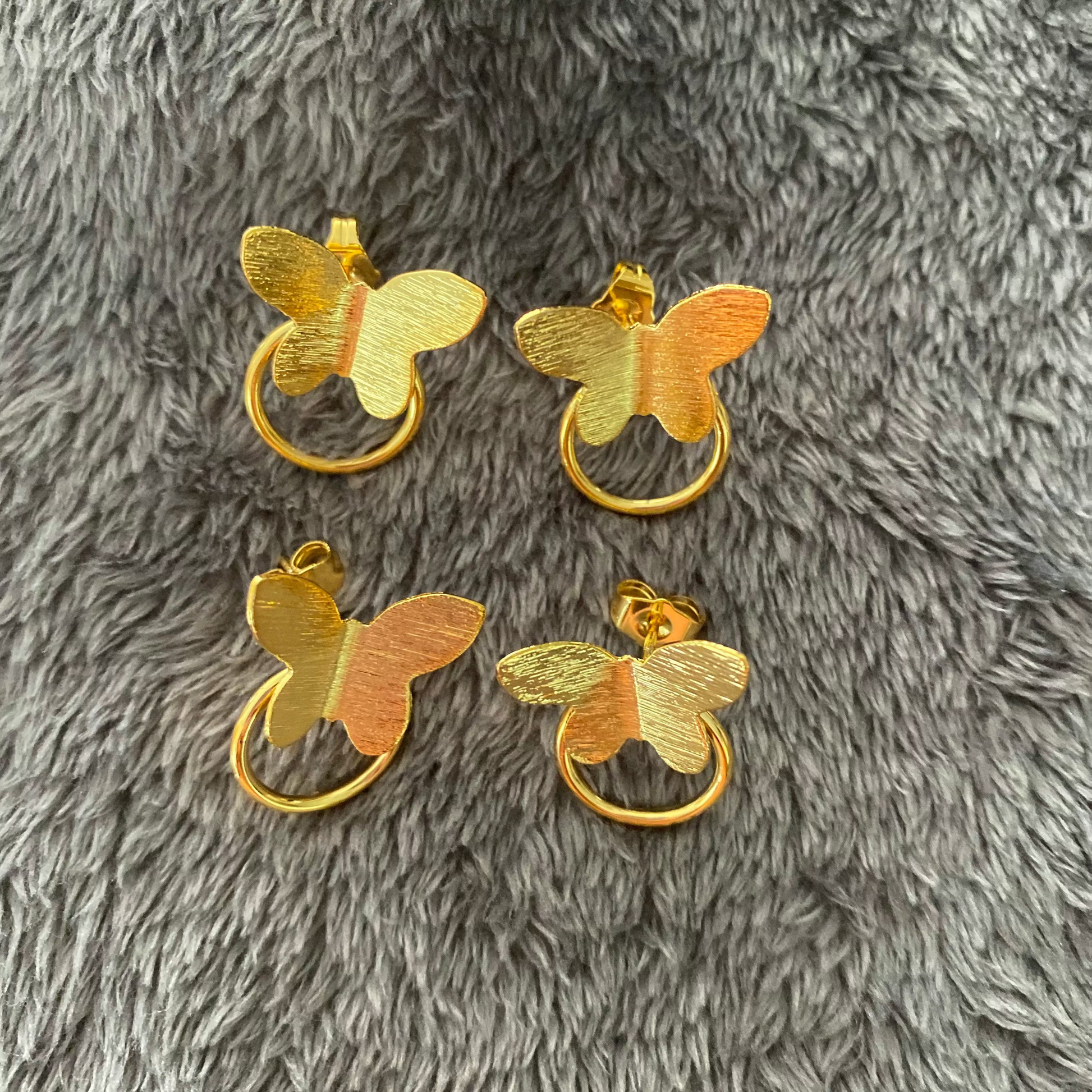 Gold butterfly-shaped door handles on a gray textured surface