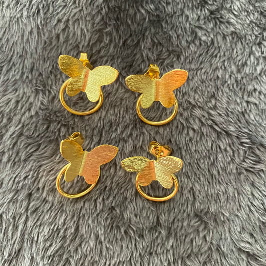 Gold butterfly-shaped door handles on a gray textured surface