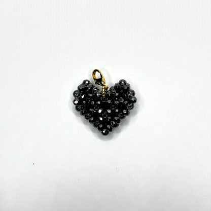 Heart-shaped black beaded pendant with gold chain on a white background