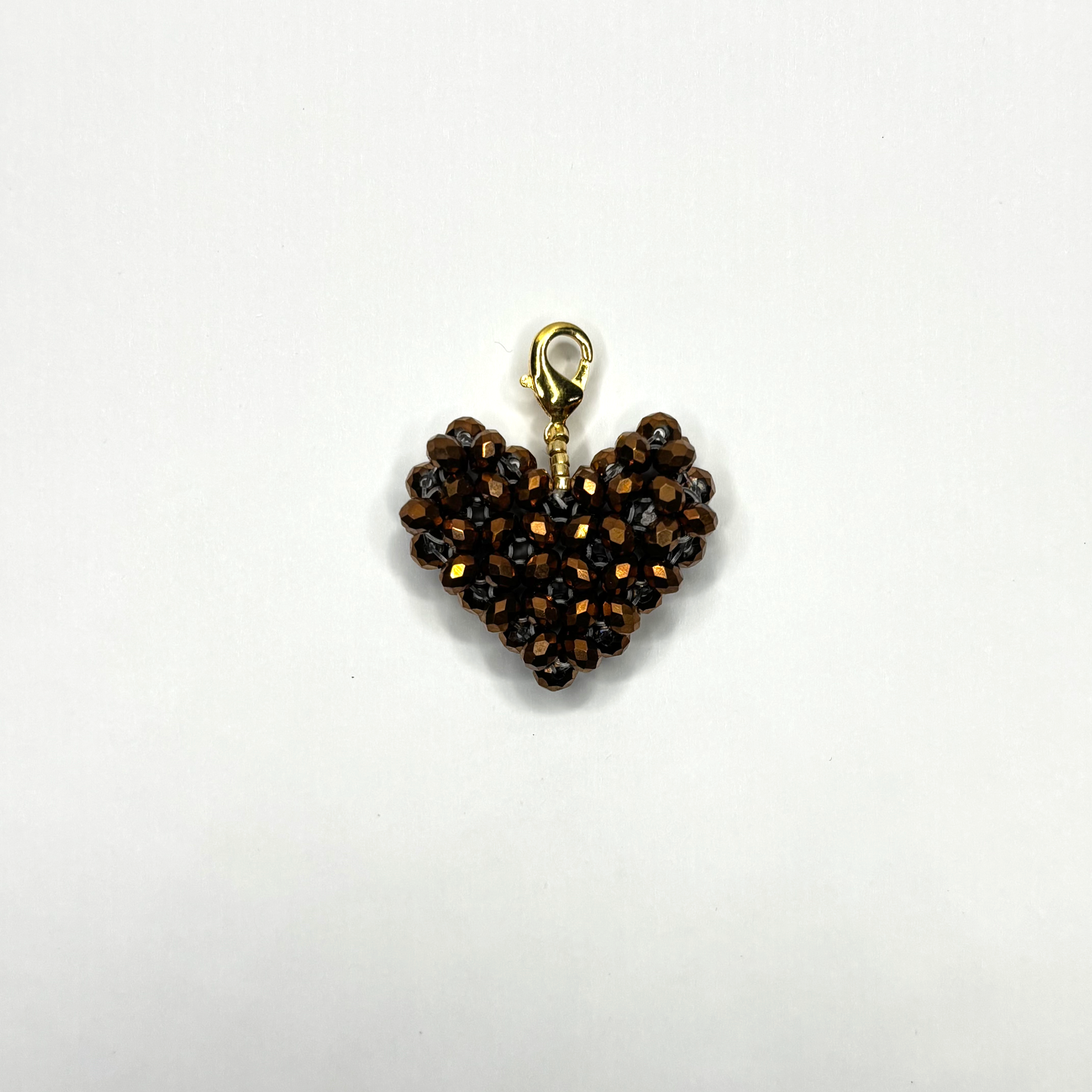 Heart-shaped charm with brown beads on a white background