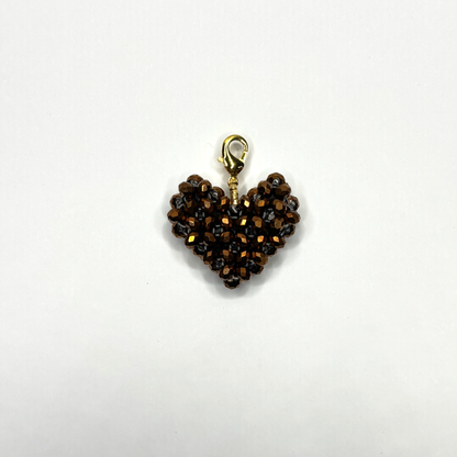 Heart-shaped charm with brown beads on a white background