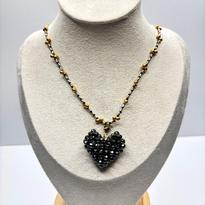 Necklace with a black heart-shaped pendant on a mannequin bust.