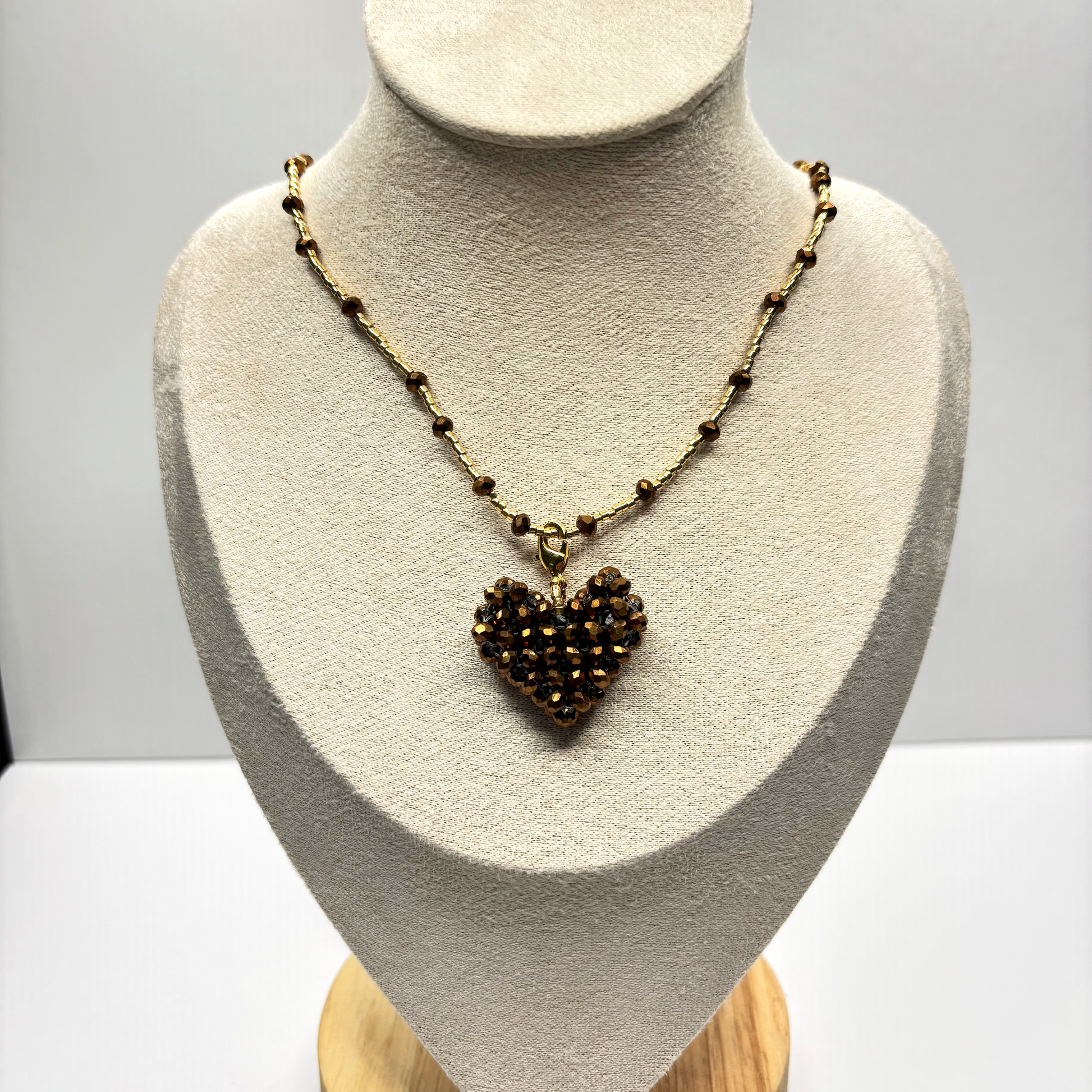 Necklace with a heart-shaped pendant on a mannequin bust against a white background