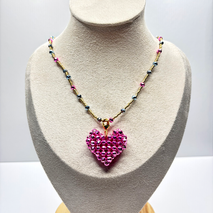 Necklace with a pink heart pendant on a mannequin bust against a white background
