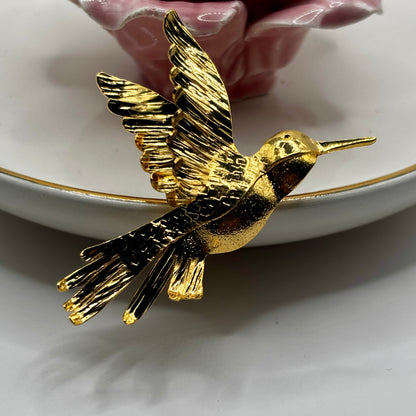 Close-up of an elegant hummingbird fancy pin brooch with sparkling gemstone details and vibrant colors.