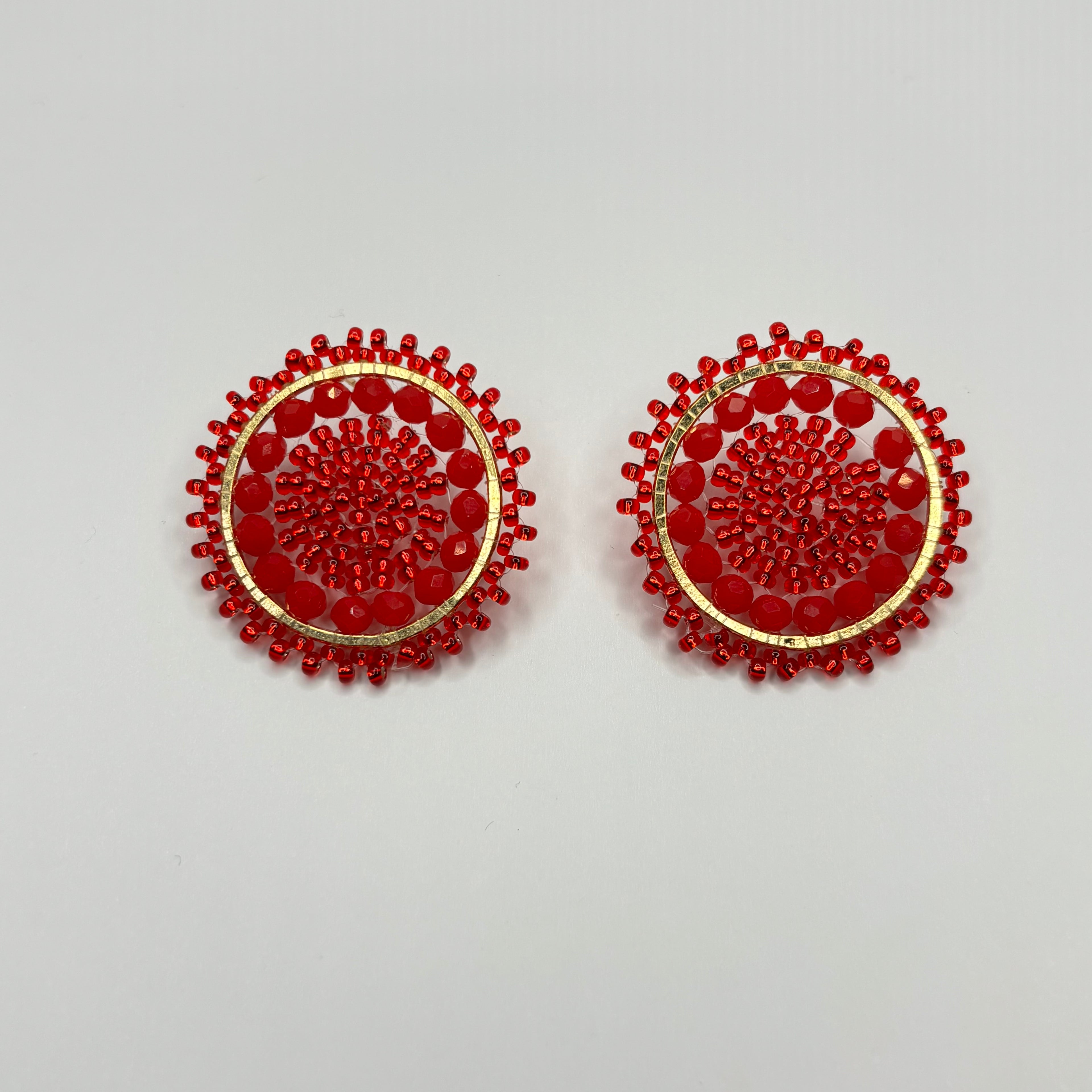 Pair of red beaded earrings on a light gray background