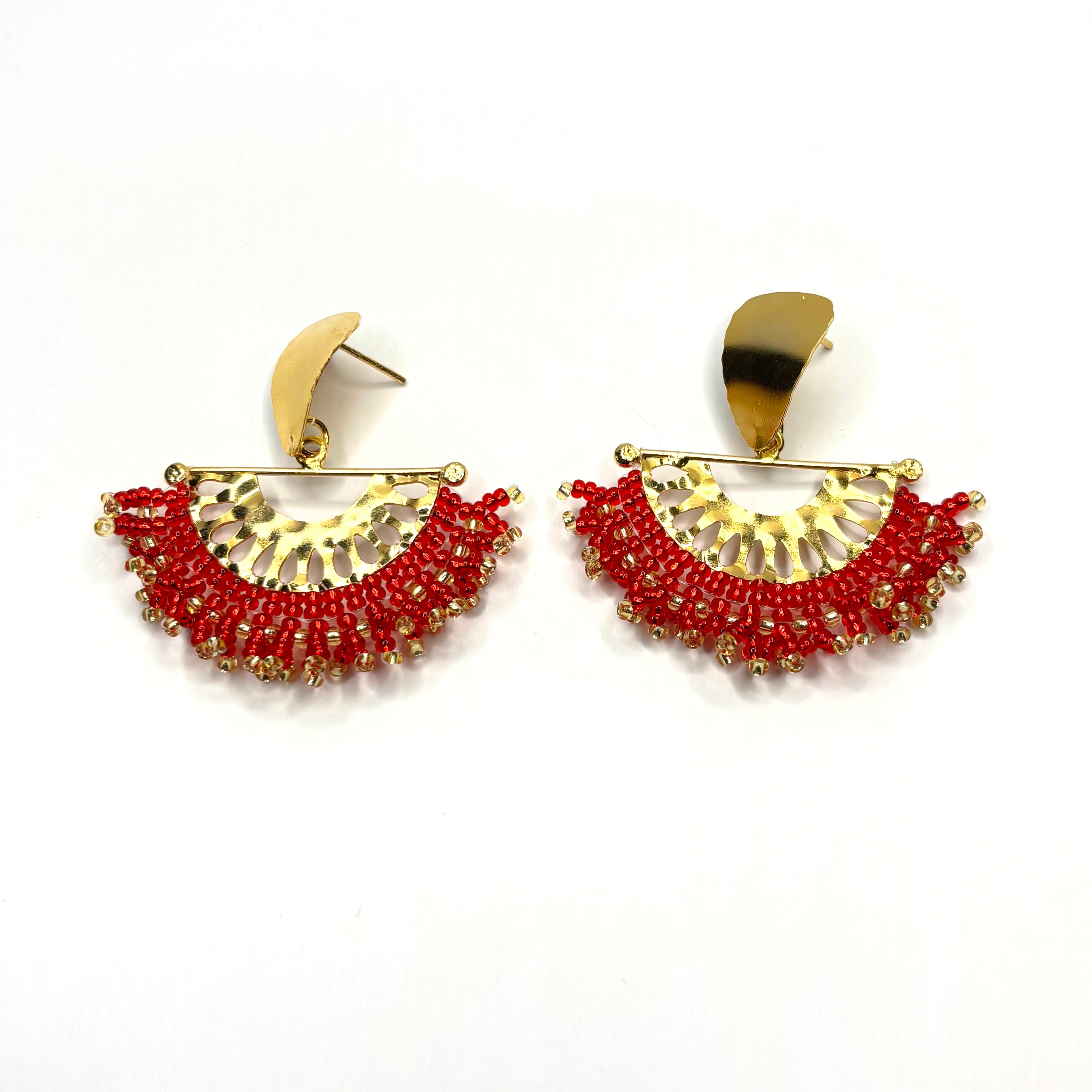 Pair of gold and red earrings on a white background