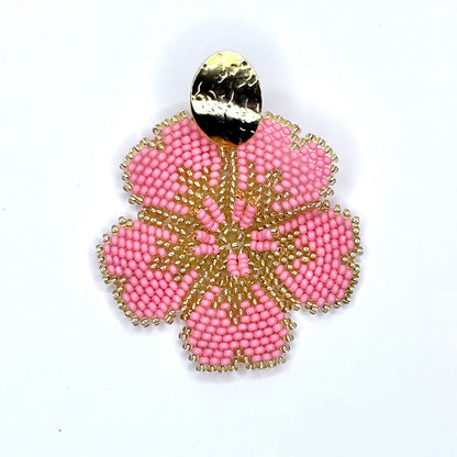 Salmon beaded earring with gold accents on a white background